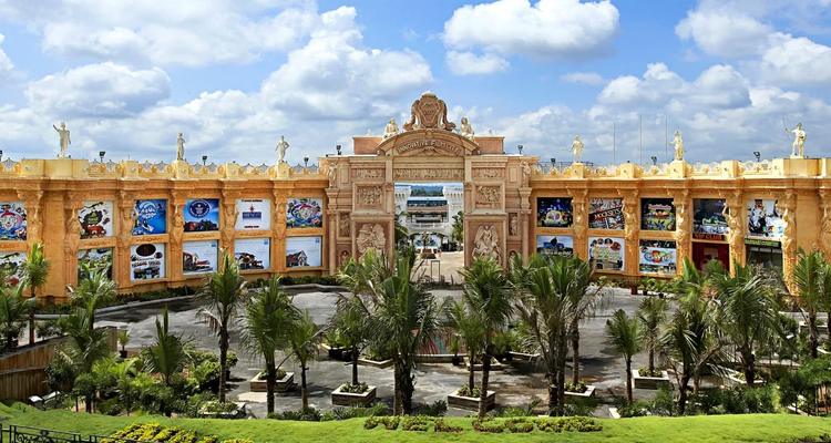 Majestic entrance of Innovative Film City with golden sculptures & vibrant posters.