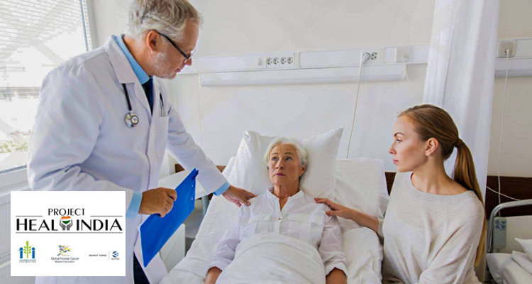 Doctor consulting an elderly patient in a hospital bed with a caring & Project Heal India.